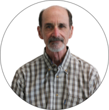 A man with a beard wearing a grey and white checked shirt